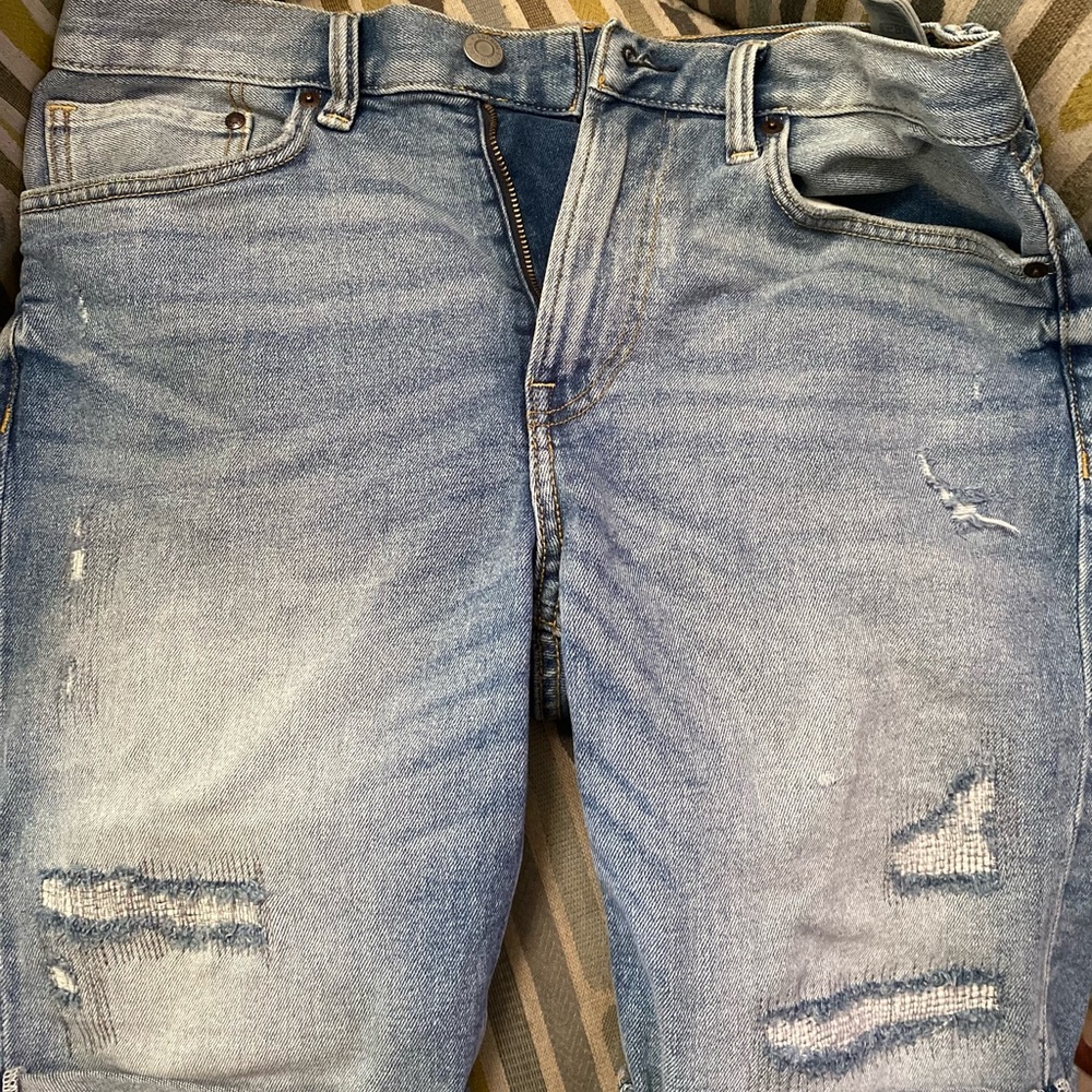 Men’s jean shorts with rips.